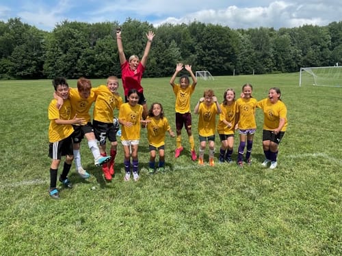 Photo of team with coach jumping